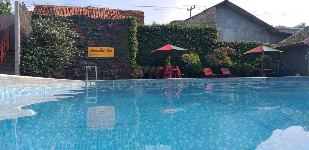 una piscina con sillas y sombrillas en un patio en Grand Ciwareng Inn Hotel and Resort, en Pasarsenen