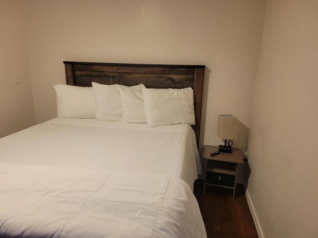 a bedroom with a white bed with a wooden headboard at 084A Cozy Retreat with Kitchen nr South Rim Sleeps 4 in Valle
