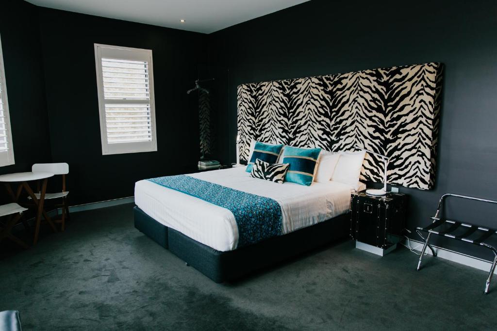 um quarto com uma cama com almofadas azuis e brancas em Junction Hotel em Newcastle