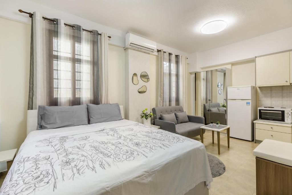 a bedroom with a large bed and a kitchen at PEARL STUDIO free private parking in Thessaloniki