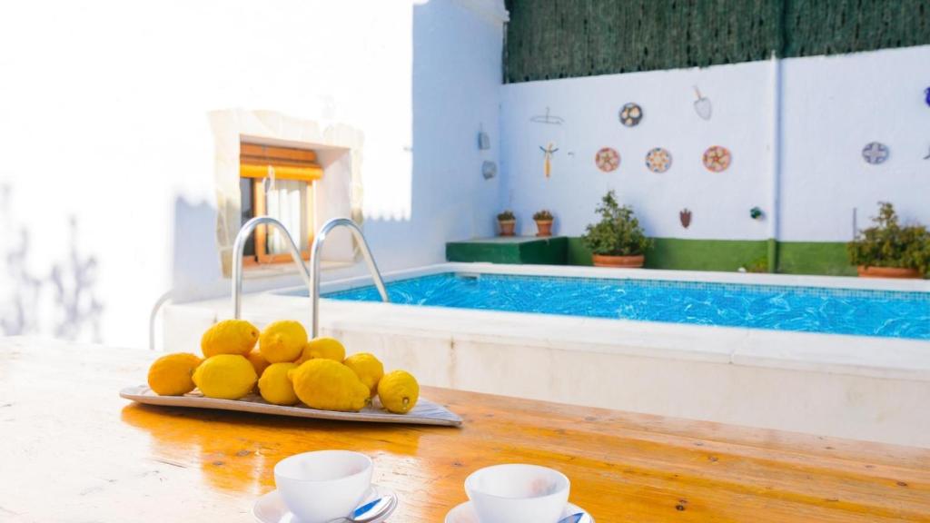 un piatto di frutta su un tavolo accanto a una piscina di Vivienda Rural Pepe el del Aceite Trasmulas by Ruralidays a Granada