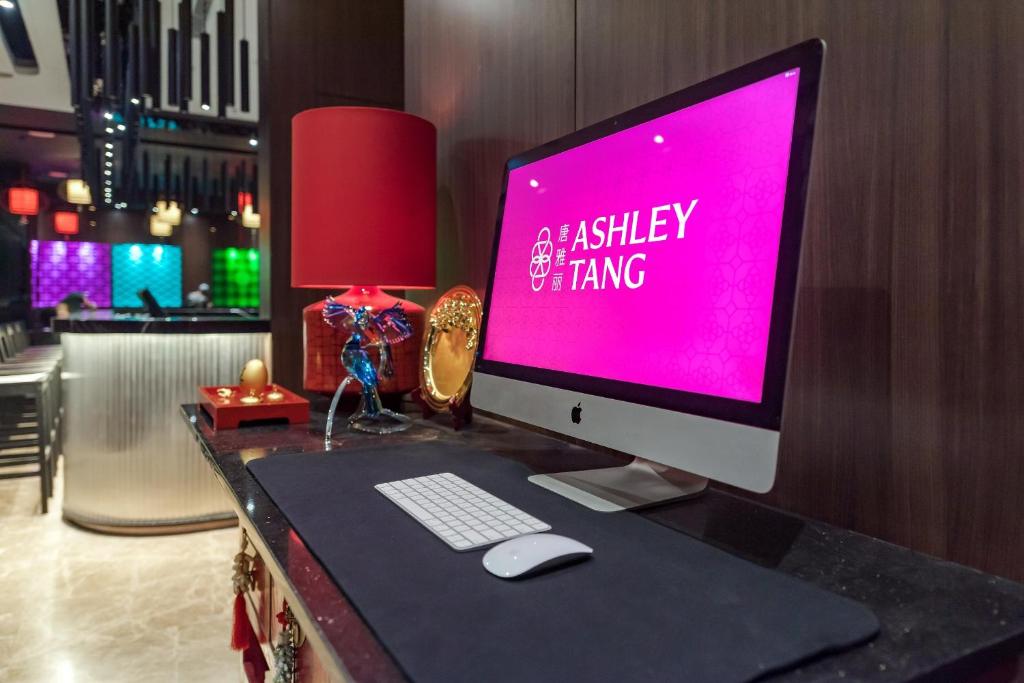 a desk with a computer monitor and a keyboard and mouse at Ashley Tang Menteng Jakarta in Jakarta