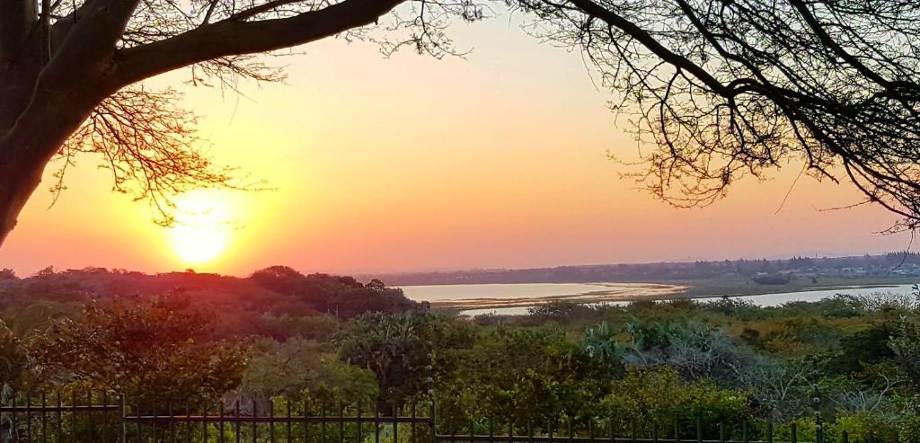 a sunset over a river with the sun setting at Hillton Manor Guest House in Richards Bay