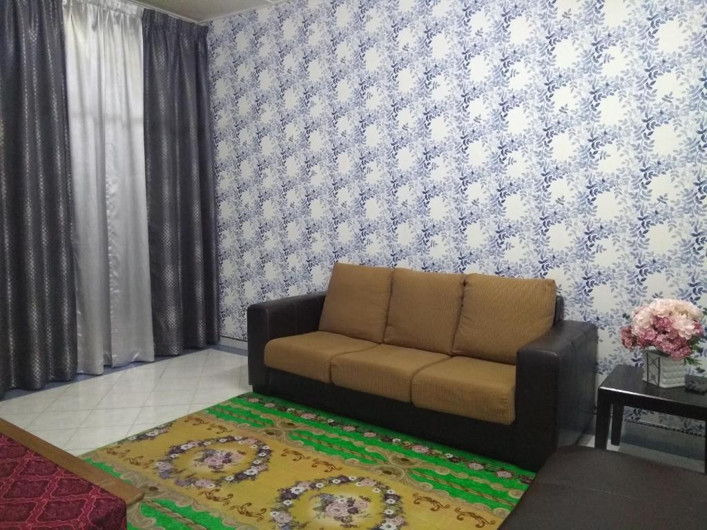 sala de estar con sofá y alfombra en Rumah Tamu AZ Pasir Tumboh, en Kampong Binjai