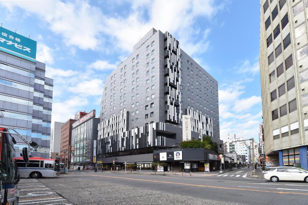 a tall building on a street in a city at HOTEL GLOBAL VIEW Niigata in Niigata