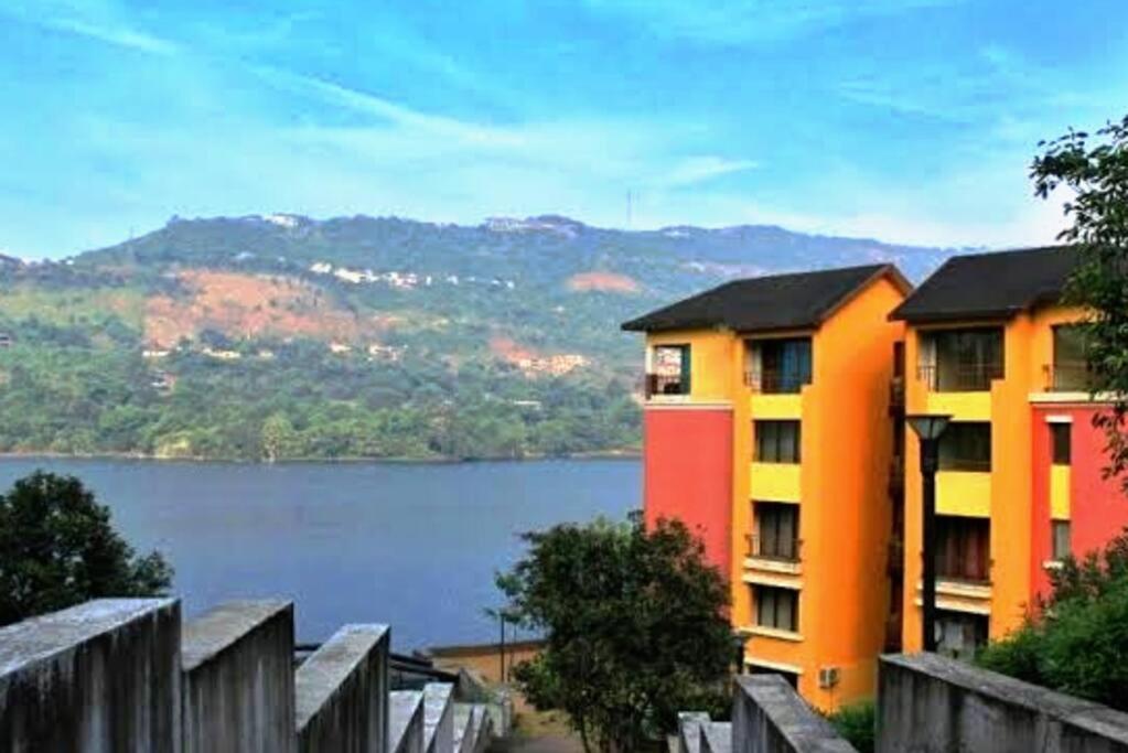 two apartment buildings with a view of a lake at PORTOFINO in Lavasa