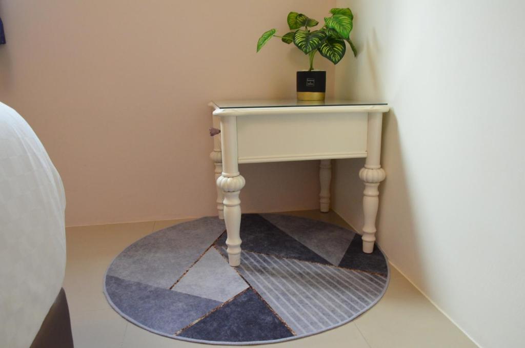 a table with a plant on top of a rug at Piau Po 21 Inn in Taitung City