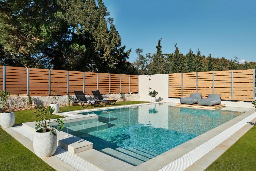 a swimming pool in a backyard with a fence at Villa Danae Zante in Zakynthos