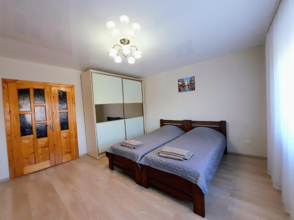 een slaapkamer met een bed en een houten vloer bij Двокімнатна квартира біля басейну in Berehove