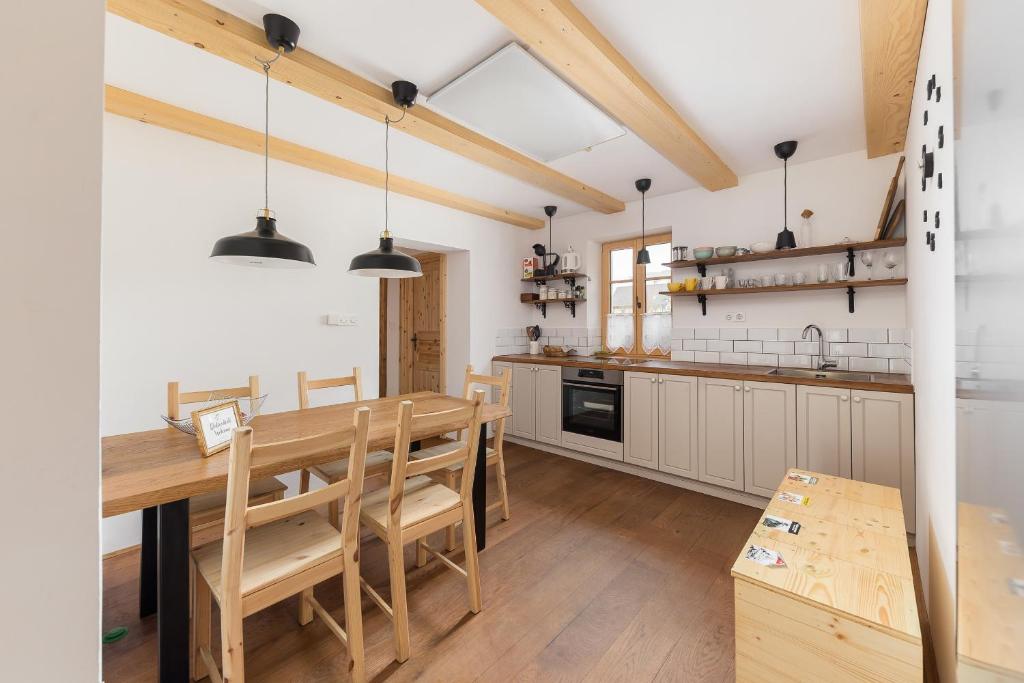 eine Küche und ein Esszimmer mit einem Holztisch in der Unterkunft Hiša na soncu / Sun house in Zgornje Gorje