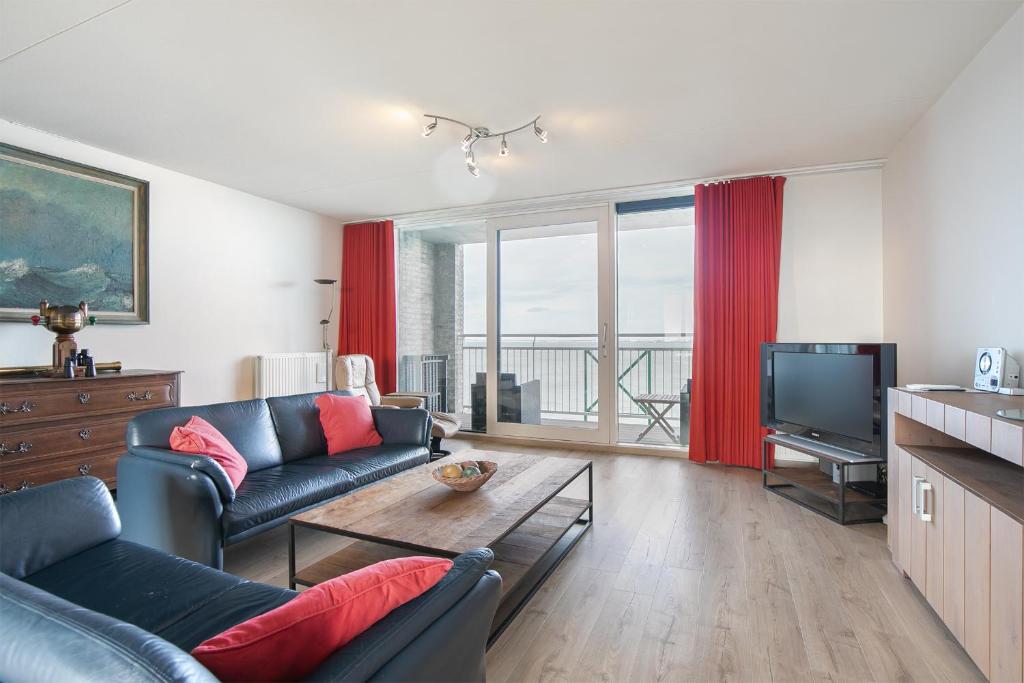 uma sala de estar com um sofá e uma televisão em Hello Zeeland - Appartement Port Scaldis 03-071 em Breskens