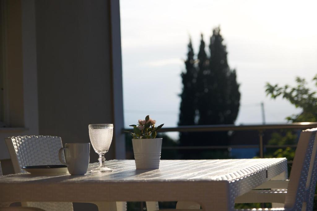 stół z dwoma kieliszkami i doniczką. w obiekcie Casa Di Calma Four Seasons Guest House w mieście Kastríon