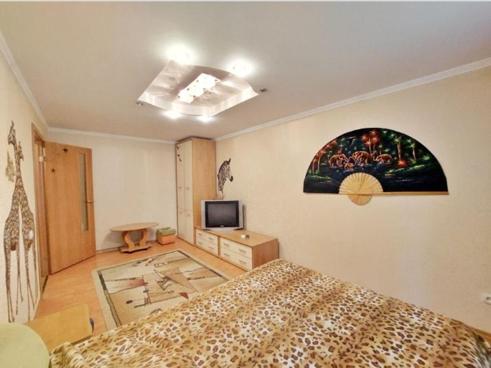 聶伯城的住宿－пр. Александра Поля 100, центральная часть города，卧室配有一张床,墙上挂有绘画作品