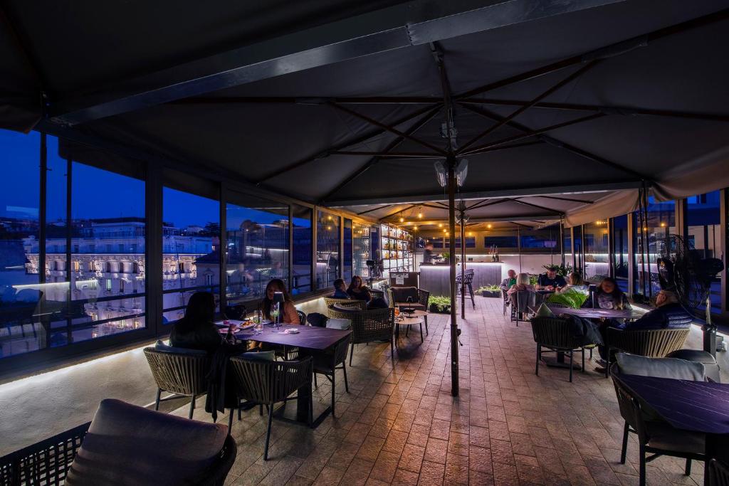 a restaurant with tables and people sitting at tables at Hotel 87 eighty-seven - Maison d'Art Collection in Rome