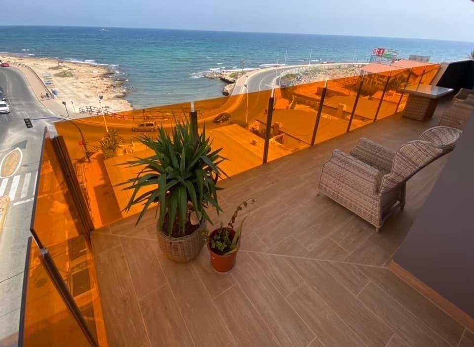 balkon z 2 krzesłami i widokiem na ocean w obiekcie Silvia luxury apartment w mieście Torrevieja