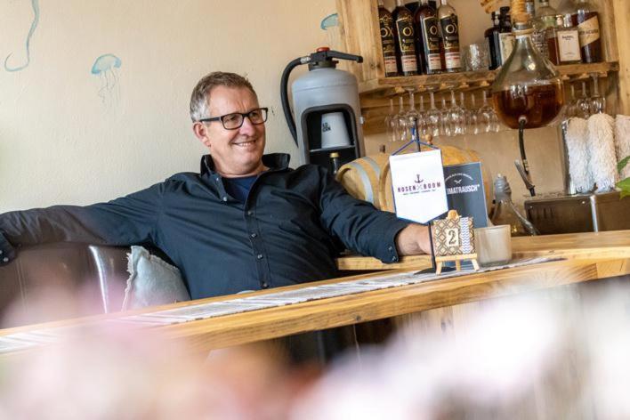 a man standing behind a counter at a practition at Gasthaus Hotel Rosenboom in Nottuln