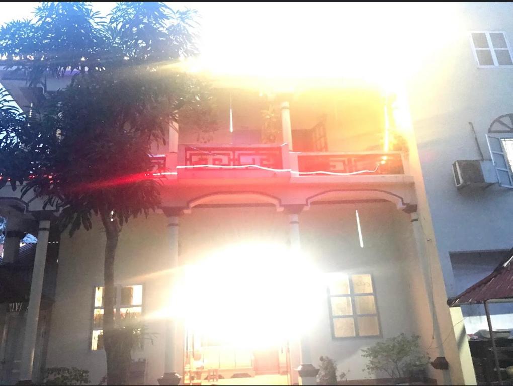 un edificio con el sol brillando en la parte delantera en Nhà Nghỉ Bình Dân Xanh en Bắc Quang