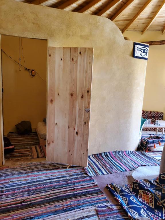 a wooden door in a room with a rug at Hidden place in Siwa