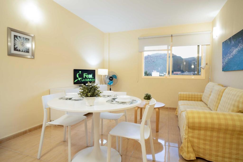 een kleine woonkamer met een witte tafel en stoelen bij Miramar 3 in San Sebastián de la Gomera