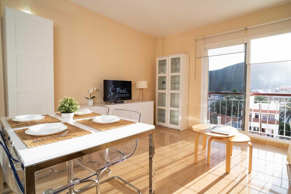 a dining room with a table and chairs and a television at Miramar 4 in San Sebastián de la Gomera