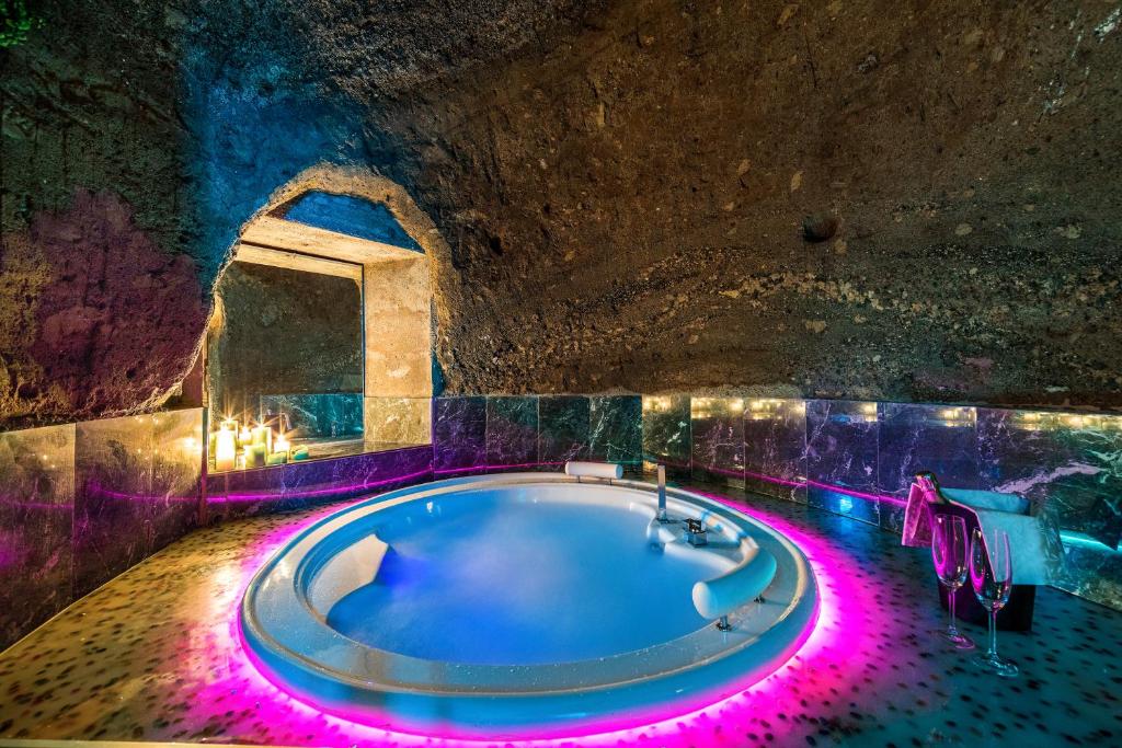ein Badezimmer mit einer Badewanne mit violetten Lichtern in der Unterkunft Il Confessionale in Castelnuovo di Porto