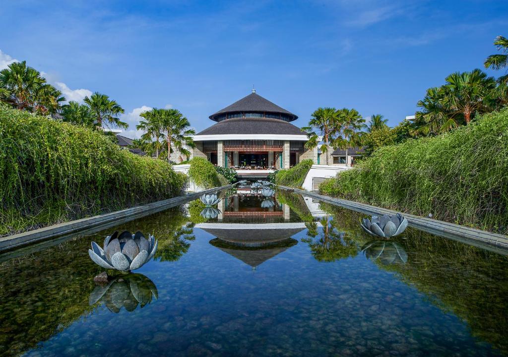 a house with a pool of water in front of it at Suites & Villas at Sofitel Bali in Nusa Dua