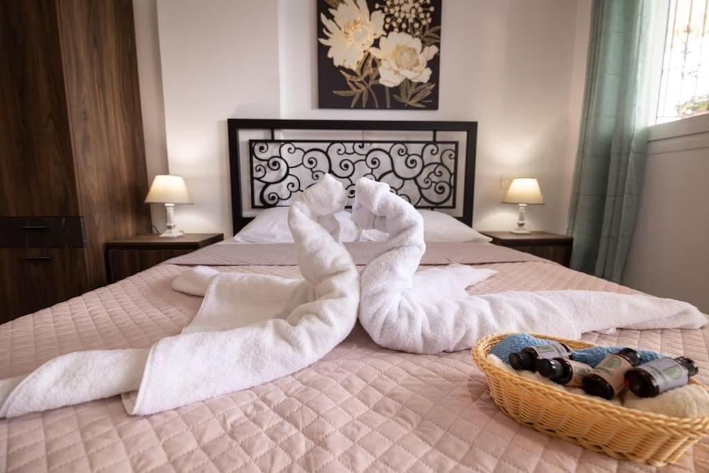a bed with white towels and a basket of bottles at Ioannis Rooms Δωμάτια με θεα στη θαλασσα in Paránimfoi