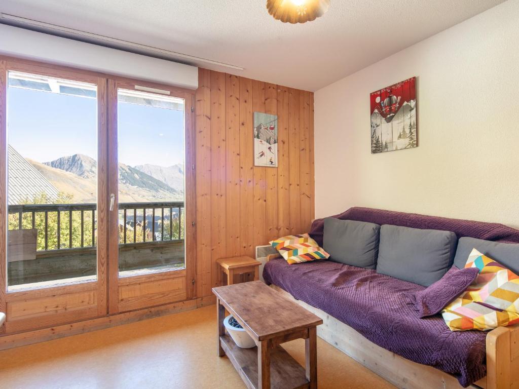 d'un salon avec un canapé et un balcon. dans l'établissement Les Marmottes- 35 Appart Lumineux- 5 pers, à Saint-Sorlin-dʼArves