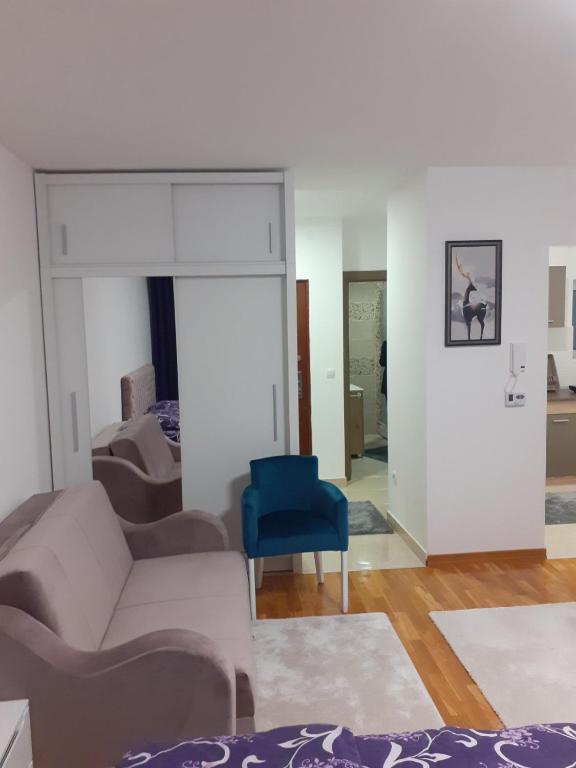 sala de estar con sofá y silla azul en Apartman JOVANA, en Vršac