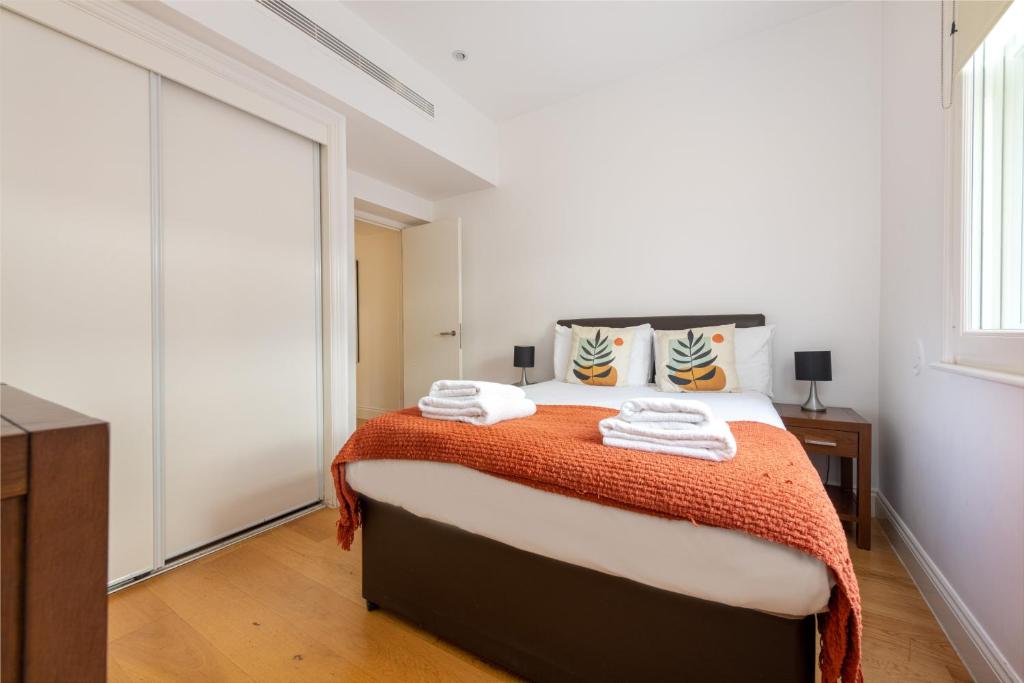 a bedroom with a bed with towels on it at Stayo Oxford Street in London