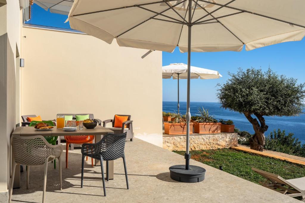 a patio with a table and chairs and an umbrella at Joy Aqua in Skala