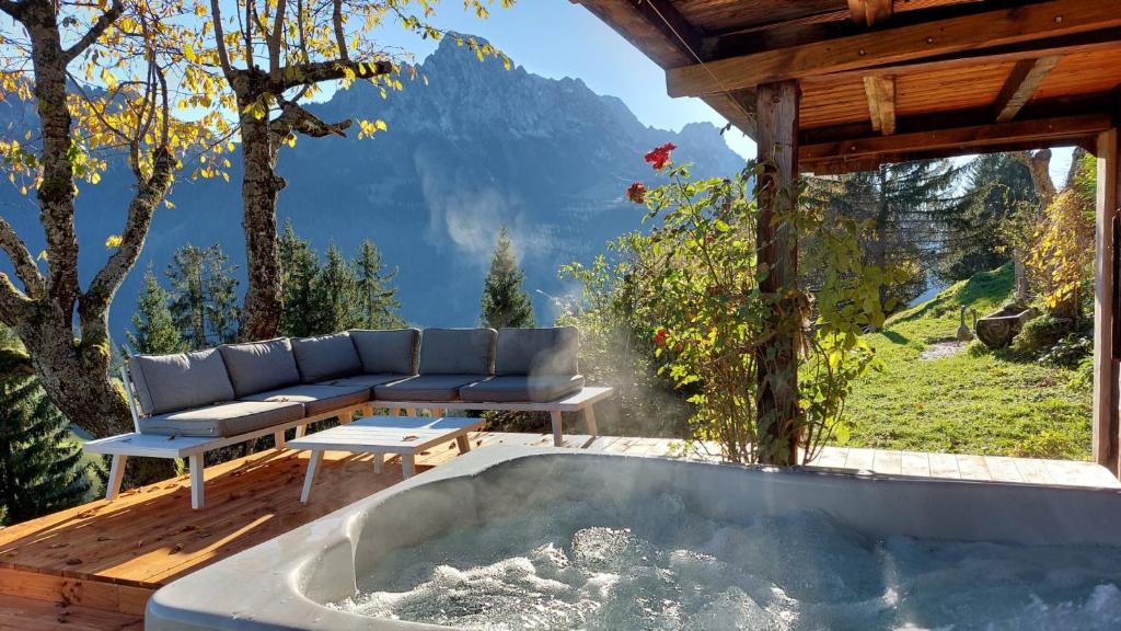 bañera de hidromasaje en la terraza de una casa con vistas en Gstaad Paradise View Chalet with Jacuzzi, en Rougemont