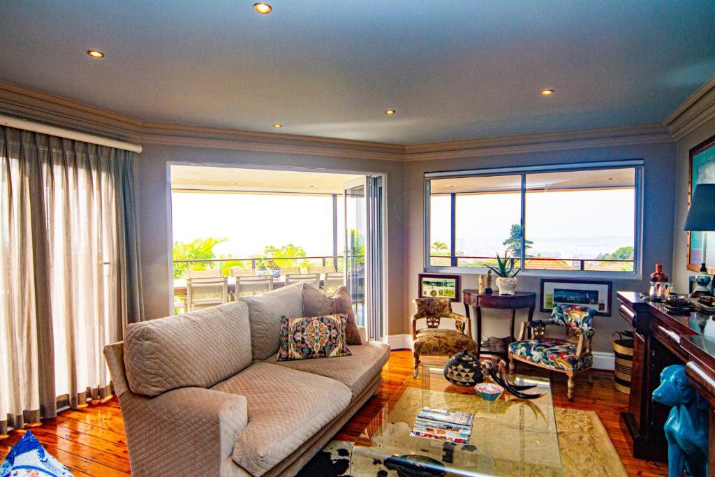 a living room with a couch and two large windows at Pete's Place in Durban