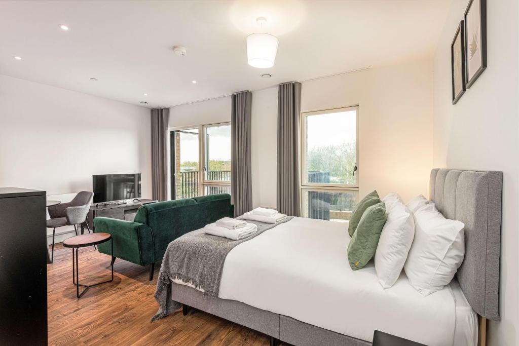 a hotel room with a large bed and a desk at Stayo Apartments Barking Wharf in London