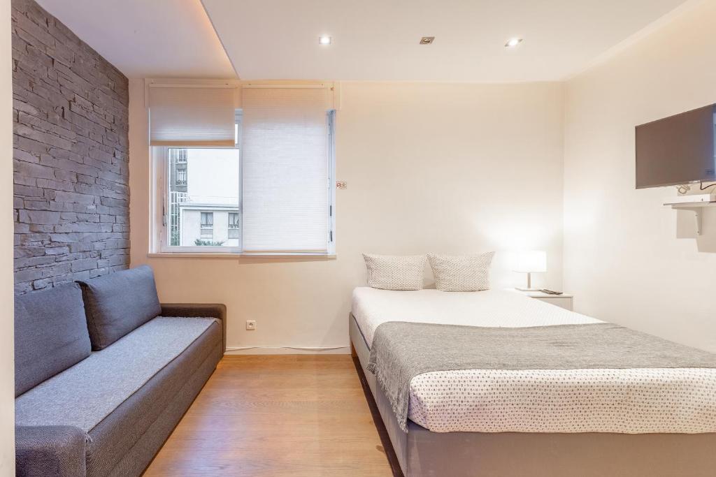 ein Schlafzimmer mit einem Bett und einem Sofa in der Unterkunft Victor Hugo Flat in Paris