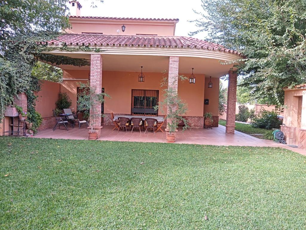 a house with a patio with a table and chairs at Casa Rural Orégano in Carmona
