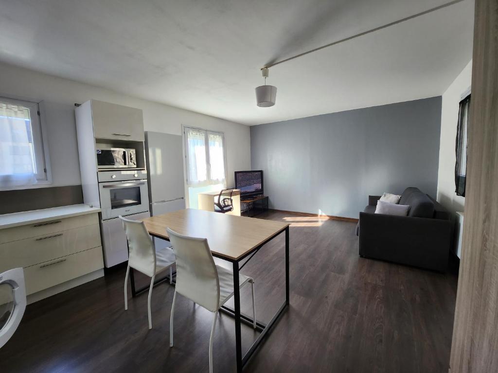 a living room with a table and chairs and a couch at Le pied à terre parisien - 77/94 in Pontault-Combault