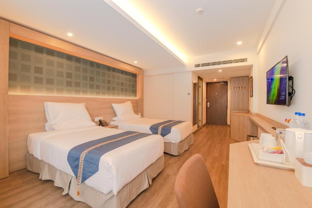Habitación de hotel con 2 camas y TV en Mila Hotel, en Katmandú
