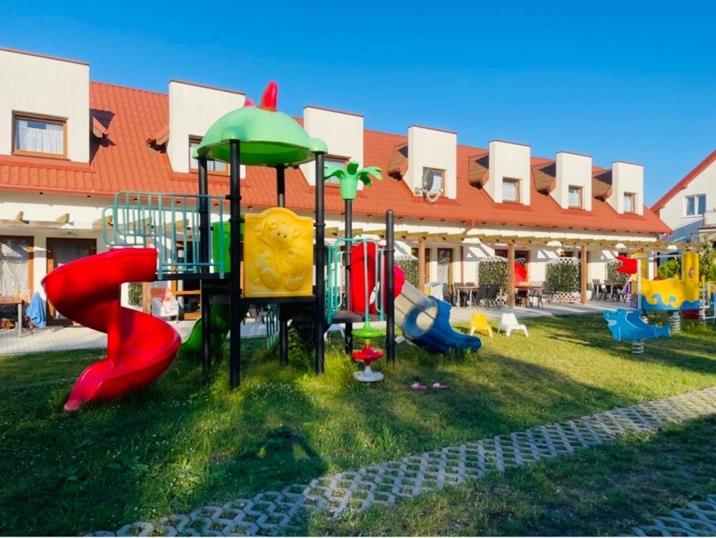 a playground in front of a building with playground equipment at Niebieskie Migdały in Grzybowo