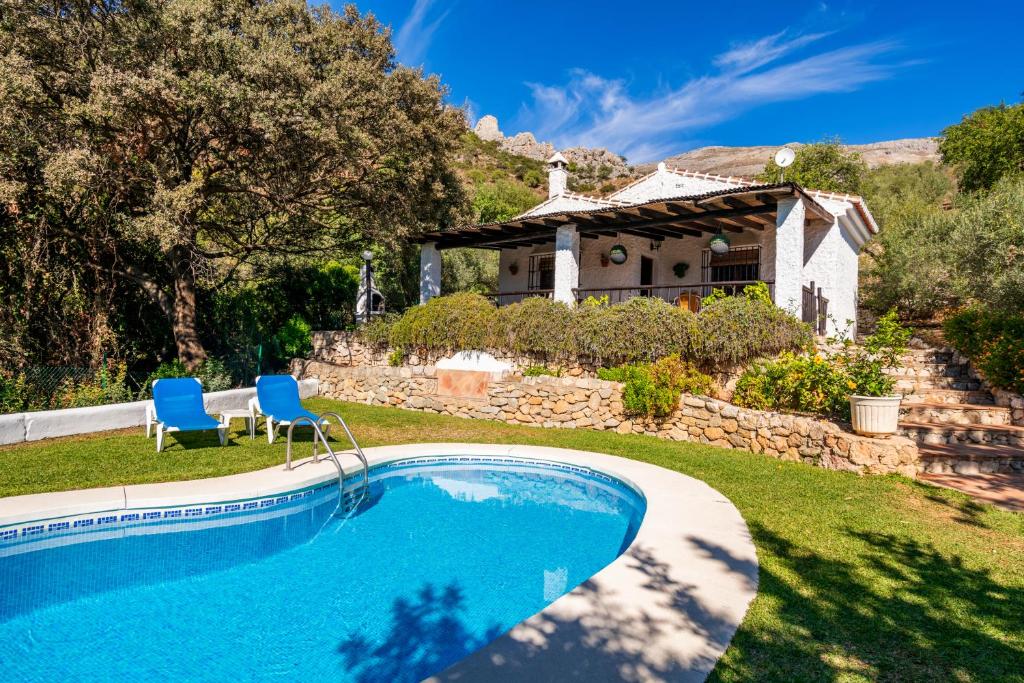a swimming pool in front of a house at El Chorro Villas Casa Adelfa in El Chorro