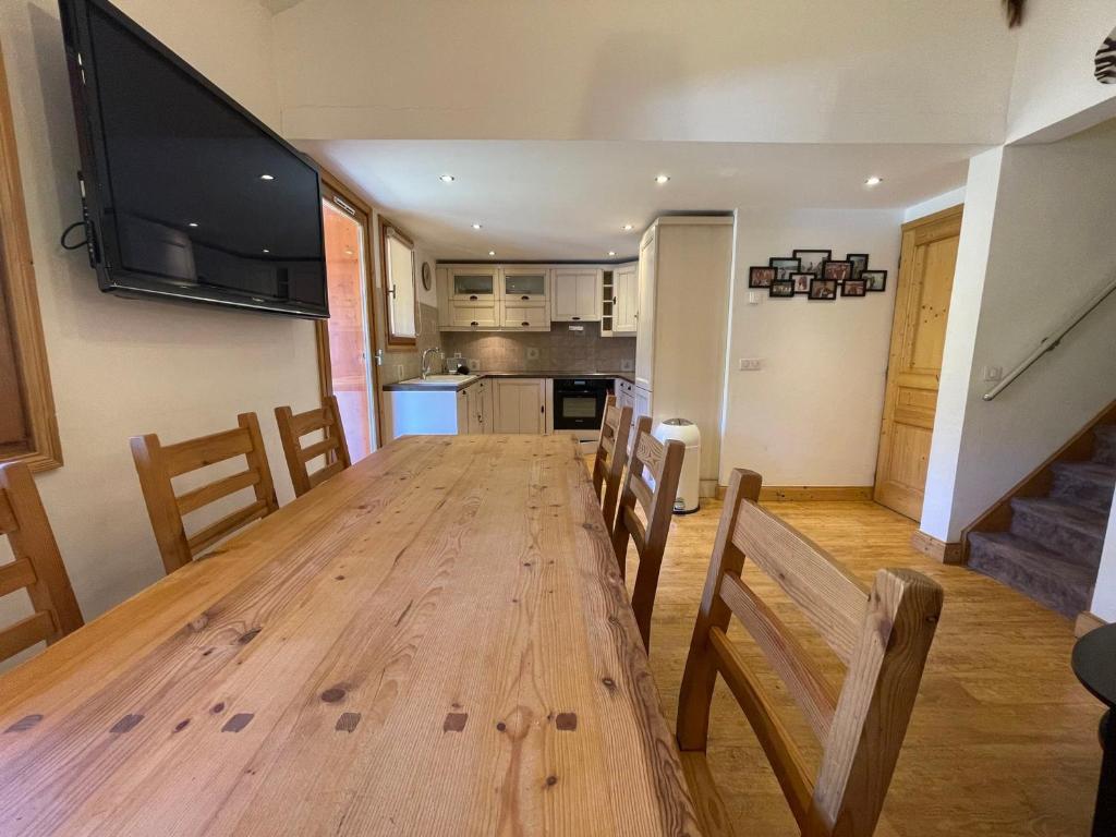 a dining room table with chairs and a flat screen tv at Appartement Tignes, 4 pièces, 6 personnes - FR-1-480-2 in Tignes