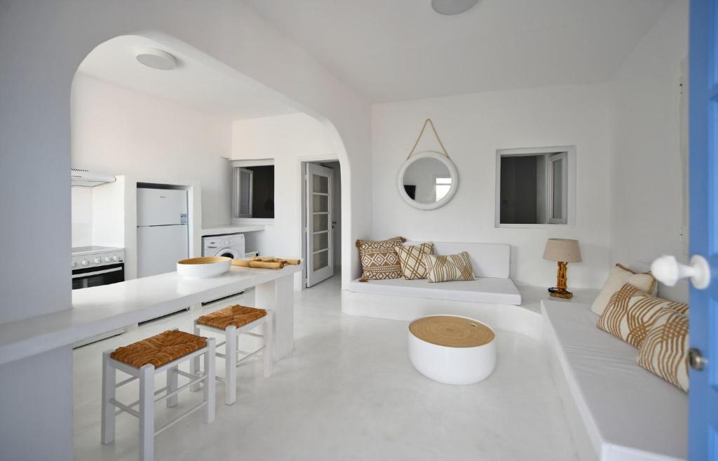una cucina bianca e un soggiorno con divano di Fully renovated 2 bedroom apartment near the restaurants and shops in Ioulida, Kea a Ioulida