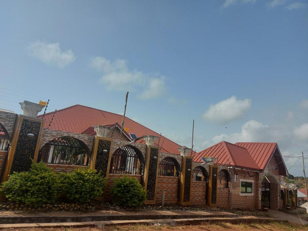 een bakstenen gebouw met een rood dak bij Masbella Airbnb in Kumasi