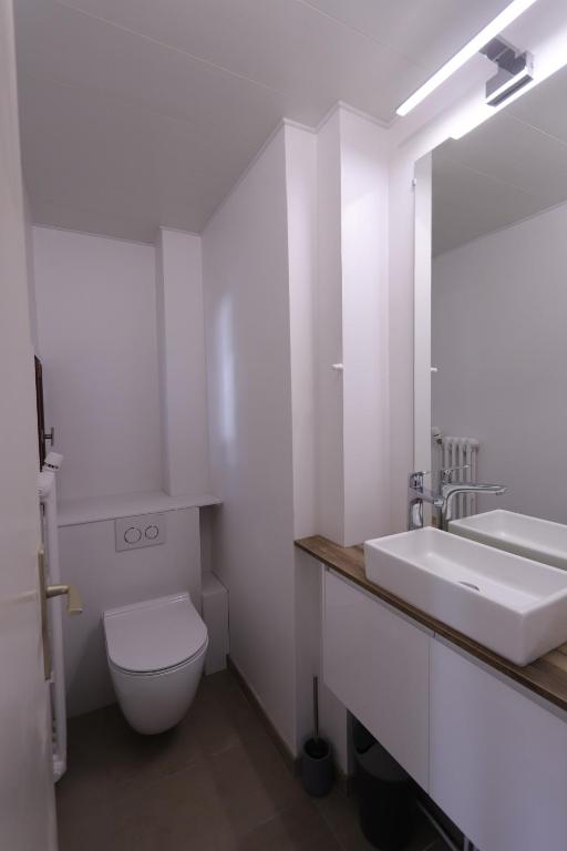 a bathroom with a sink and a toilet and a mirror at Duplex 65 m2 au coeur du golf de Tignes in Tignes