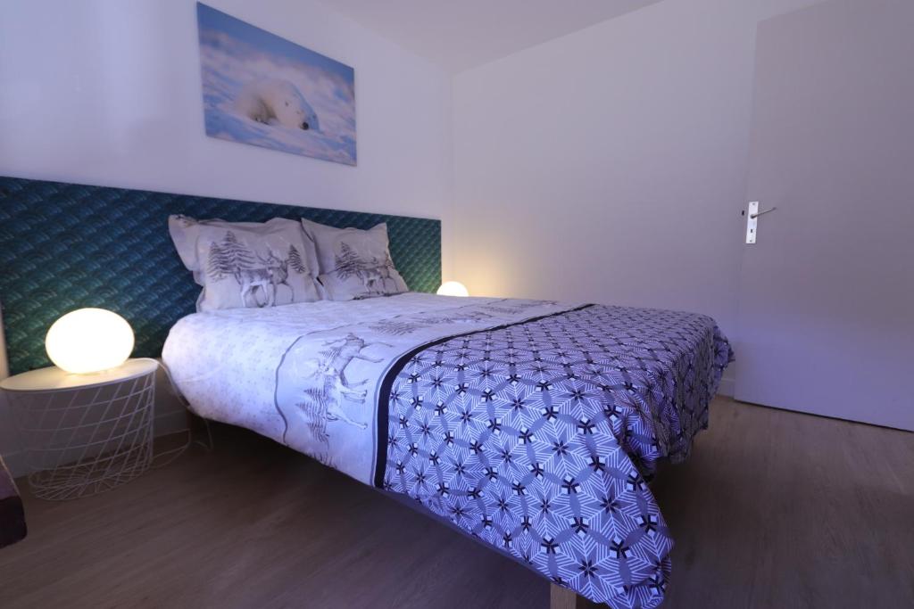 a bedroom with a bed with a purple comforter at Duplex 65 m2 au coeur du golf de Tignes in Tignes