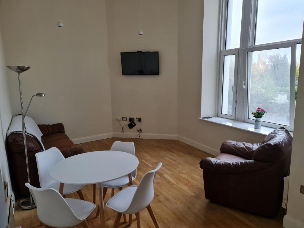 uma sala de estar com uma mesa branca e cadeiras em Luxury 2 Bedroom, and 2 Bathroom Apartment em Cardiff