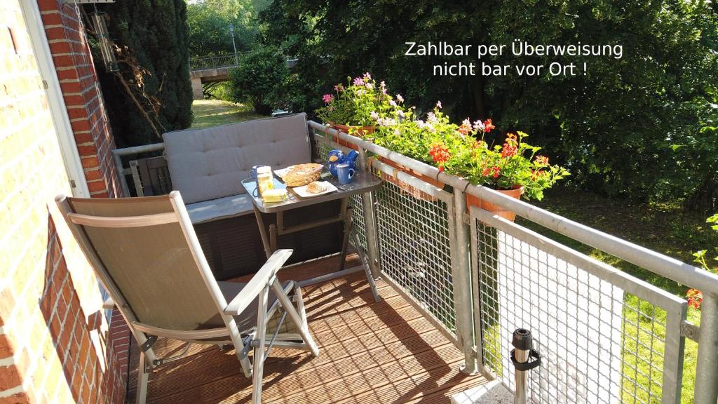 una mesa y sillas en un balcón con flores en FeWo Lüneburger Heide - Aurelia en Bad Bevensen