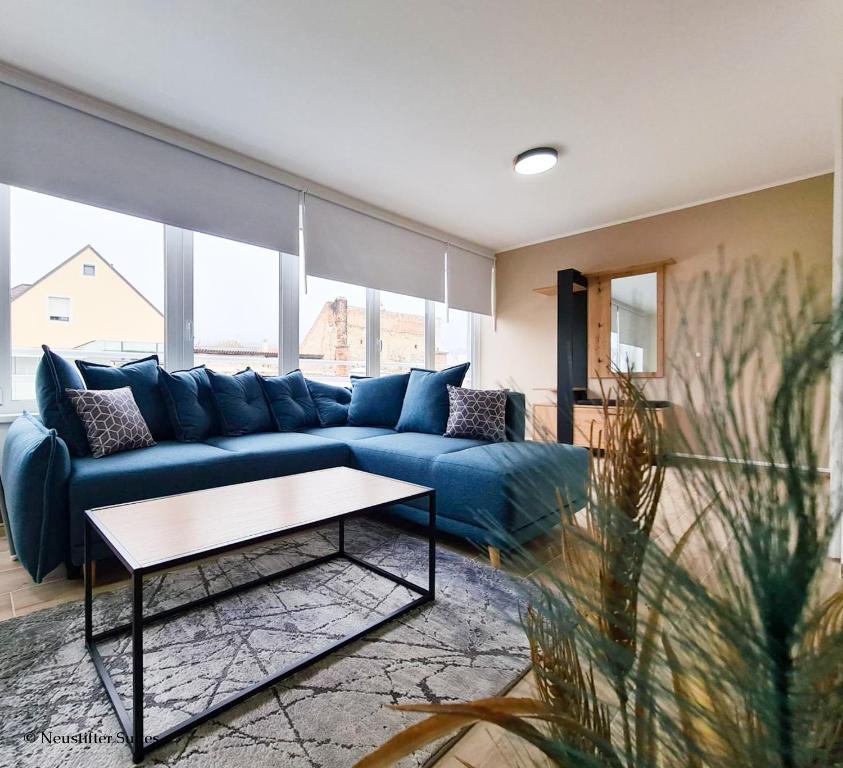 ein Wohnzimmer mit einem blauen Sofa und einem Tisch in der Unterkunft St. Antoni Suite 5 in Eisenstadt