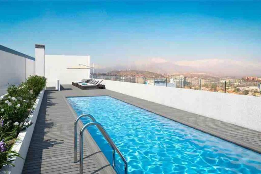 a swimming pool on the roof of a building at Fabuloso depto 2d/2b en Metro Los Dominicos in Santiago