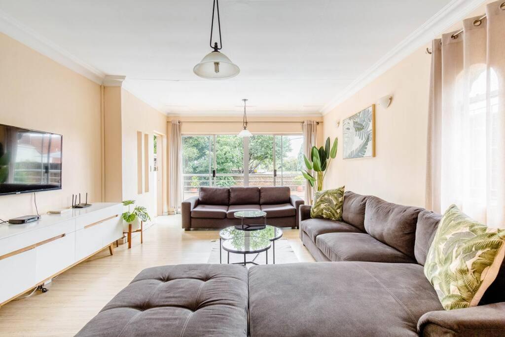 een woonkamer met een bank en een tafel bij Spacious Menlyn Maine Villa in Pretoria